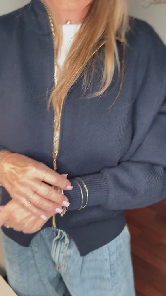 Semainier porté en accumulation aux deux poignets avec un pull marine